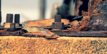 Close-up of heavily rusted metal fasteners and corroded plates