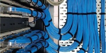 Blue network cables routed through server racks with tight bends