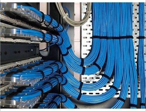 Blue network cables routed through server racks with tight bends